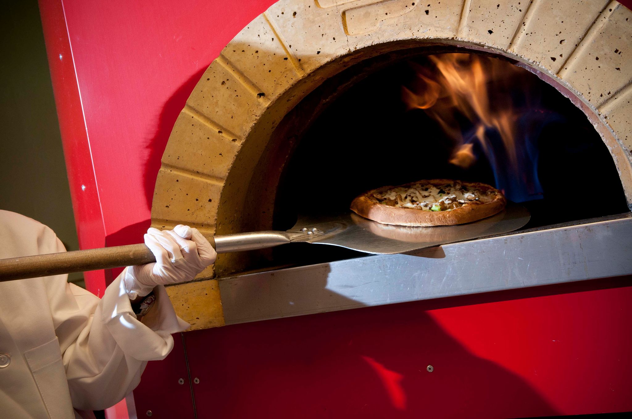 ASC Employee taking pizza oven from the oven